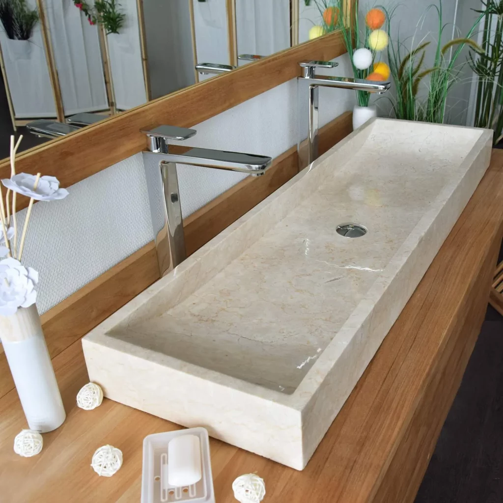 Lavabo de mármol de un seno y dos grifos.