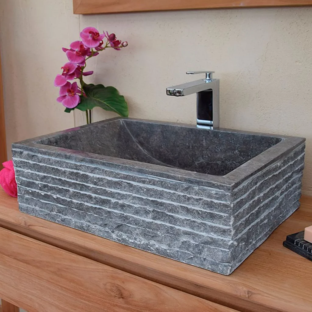 Lavabo de piedra gris de sobre encimera.